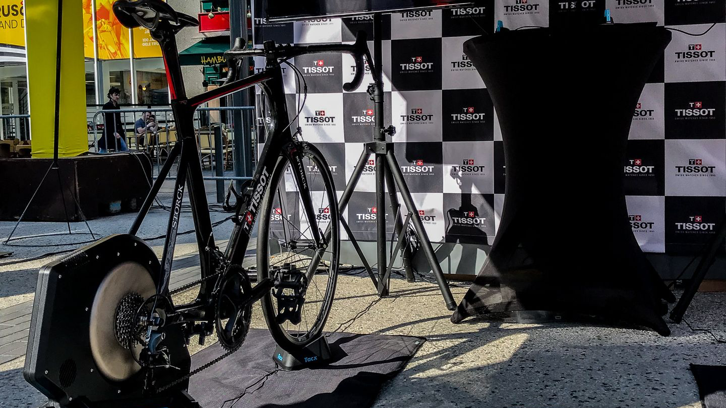Participant pédalant sur simulateur de vélo connecté avec écran de course
