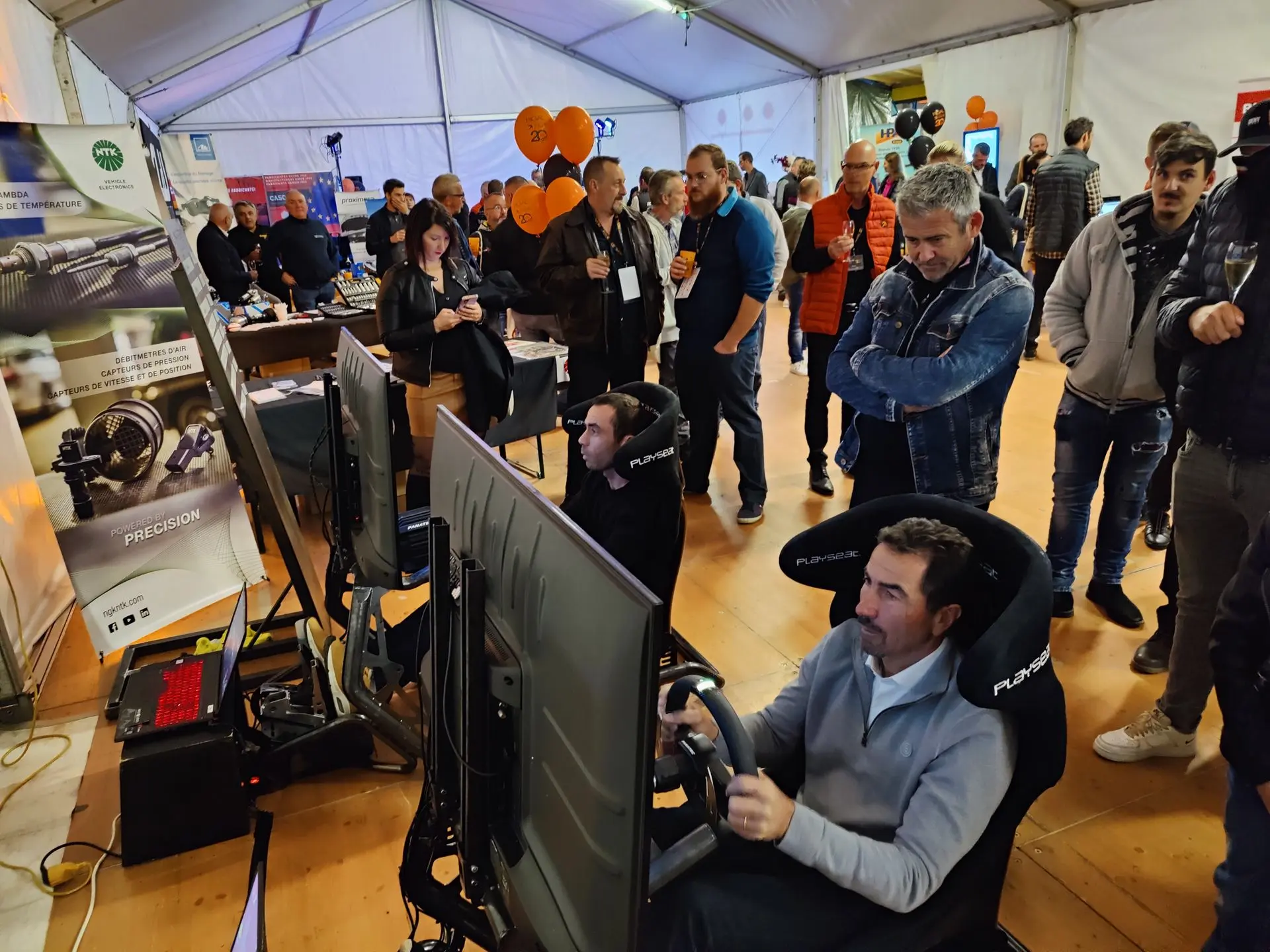 Public observant une session de course virtuelle sur écran géant événementiel